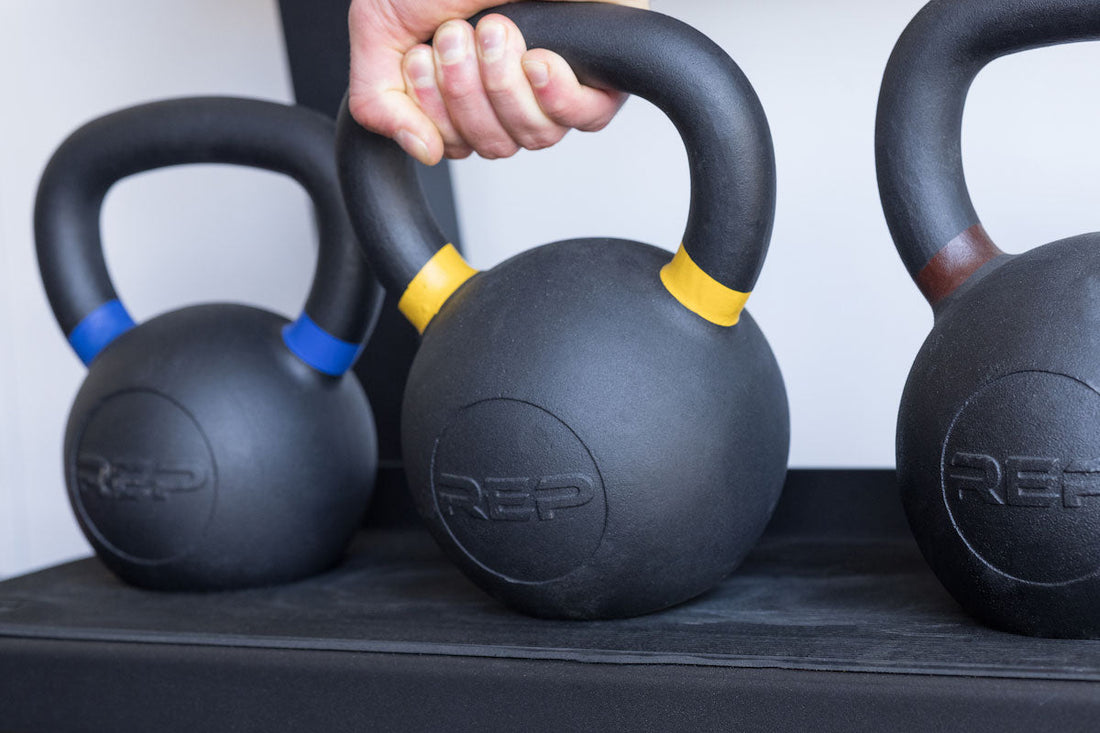 A person grabs a REP kettlebell.